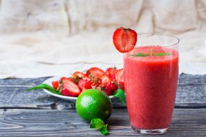 Smoothie recept: mix 100 gram aardbeien, ½ banaan, 1 handje spinazie, een beetje limoensap en water in een blender